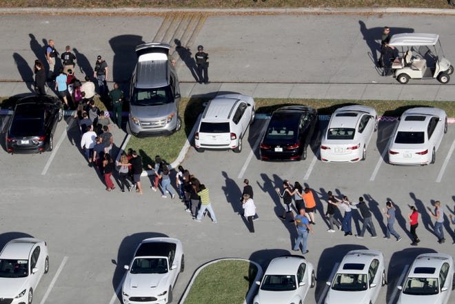 In this Feb. 14, 2018, file photo, students are evacuated by police from Marjory Stoneman Douglas High School in Parkland, Florida, after a shooter opened fire on the campus. [SOUTH FLORIDA SUN-SENTINEL VIA AP]