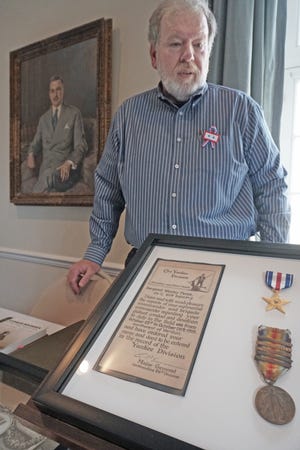 Shawn A. Pease, of Seekonk, displays items from his grandfather, Wesley Pease, who served in the U.S. Army in Europe during World War I. Shawn Pease attended the "Doughboy Roadshow," at Aldrich House in Providence, on Saturday. [The Providence Journal / Sandor Bodo]