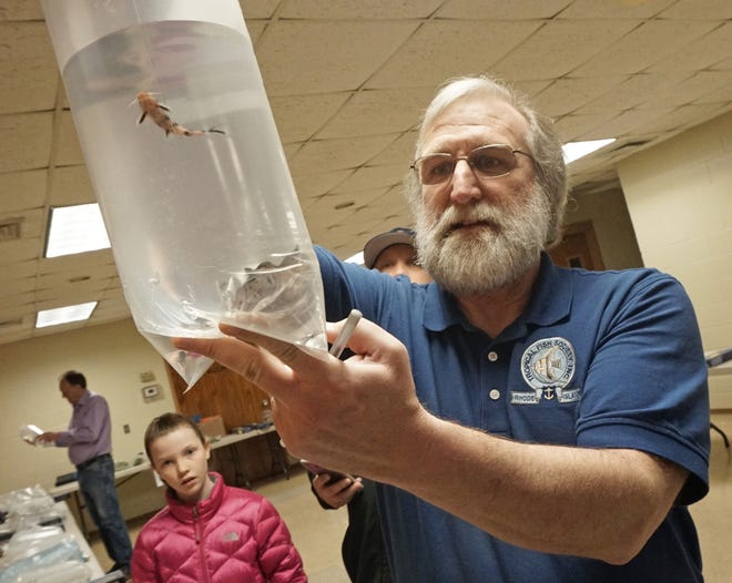 Richard Pierce, president of the Tropical Fish Society of Rhode Island, displays a bag of dwarf petricola at the society's Spring Auction on Saturday. The petricola, from Lake Tanganyika in Africa, were among the fish, aquatic plants and aquarium equipment auctioned off at St. Joseph Church parish hall in Cumberland.