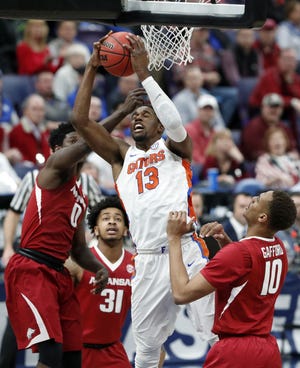 Florida's Kevarrius Hayes heads to the basket as Arkansas' Jaylen Barford (0), Anton Beard (31) and Daniel Gafford (10) defend during the first half Friday in the quarterfinals of the Southeastern Conference tournament, in St. Louis. [Jeff Roberson/The Associated Press]