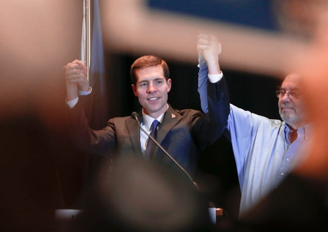 Democrat Conor Lamb, left, links arms with United Steelworkers President Leo Gerard, right, and Pennsylvania Gov. Tom Wolf, left, not visible, during a campaign rally at the United Steelworkers headquarters in Pittsburgh, Friday, March 9, 2018. Lamb is running against Republican Rick Saccone in a special election being held on March 13 for the PA 18th Congressional District vacated by Republican Tim Murphy. (AP Photo/Keith Srakocic)