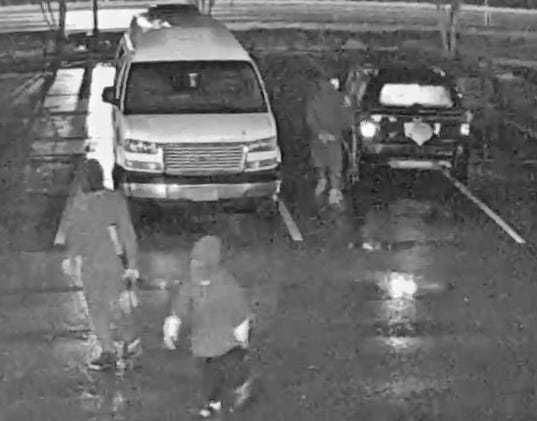 Three men, one carrying a rifle [left], get out of a Jeep (right) and head to the Spin City Sweepstakes gaming center. The Jeep's license plate appears to be covered. [Jacksonville Sheriff's Office]