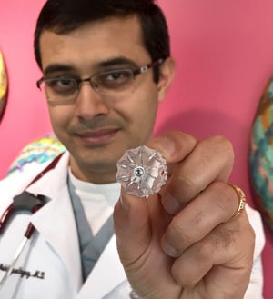 SUPPLIED PHOTO Dr. Ekanka Mukhopadhyay, a cardiologist with with OSF HealthCare Cardiovasculare Institute, holds the WATCHMAN, a device to help prevent strokes in patients with AFib.
