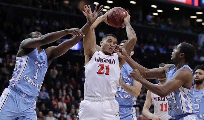 Virginia forward Isaiah Wilkins (21) pulls down a rebound between North Carolina forward Theo Pinson (1), guard Kenny Williams (24) and forward Luke Maye (32) during the second half of an NCAA college basketball game for the Atlantic Coast Conference men's tournament title Saturday, March 10, 2018, in New York. Virginia won 71-63. (AP Photo/Julie Jacobson)