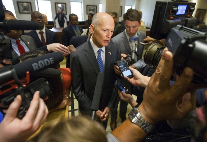 Florida Governor Rick Scott talks to the media at the end of the legislative session at the Florida State Capitol in Tallahassee on Sunday. The ending of the legislative session in Florida is call Sine Die and is signaled with the ceremonial dropping of the handkerchief from the Florida House and Senate. [ MARK WALLHEISER / AP ]