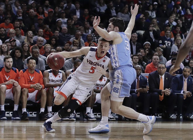 Virginia guard Kyle Guy drives against North Carolina guard Andrew Platek during the second half of the Atlantic Coast Conference men's title game Saturday in New York. Virginia won 71-63. [Julie Jacobson/The Associated Press]