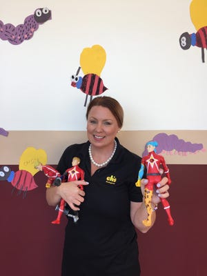 Cristina Chinchilla, a clinical counselor at South Woods Elementary School, shows off the superhero figures used in kids' group therapy. [CONTRIBUTED]