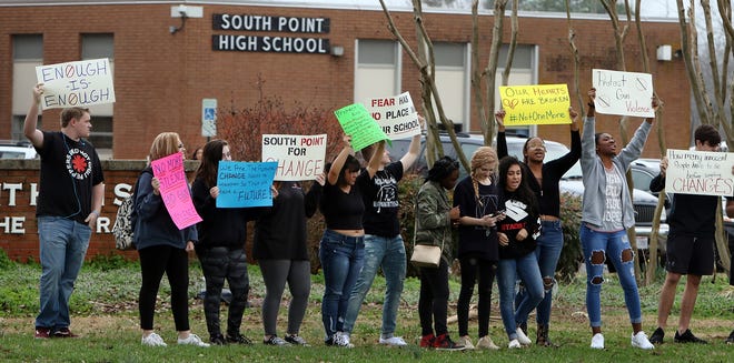 A handful of students walked out onto the grassy area in front of South Point High School in Belmont on Feb. 20, calling for change in the wake of the Florida school shooting. [Mike Hensdill/The Gaston Gazette]