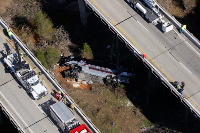 Rescue crews work at the scene of a deadly charter bus crash on Tuesday, March 13, 2018, in Loxley, Ala. The bus carrying Texas high school band members home from Disney World plunged into a ravine before dawn Tuesday. (AP Photo/Dan Anderson)