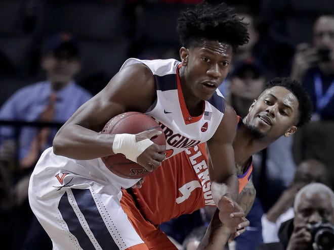FILE - In this Friday, March 9, 2018, file photo, Virginia guard De'Andre Hunter (12) pulls down a rebound next to Clemson guard Shelton Mitchell (4) during the first half of a game in the semifinals of the Atlantic Coast Conference tournament in New York. Hunter, the ACC's sixth man of the year, will miss the NCAA tournament with a broken left wrist. [AP Photo / Julie Jacobson, File]