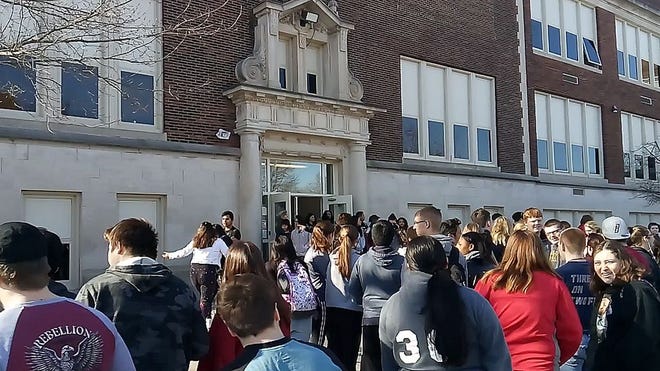 Students at Monmouth-Roseville High School take part in a national walkout Wednesday morning in remembrance of the victims in the Parkland, Fla., shooting a month ago.