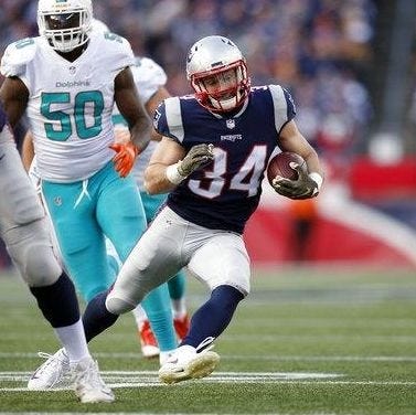 Running back Rex Burkhead, shown carrying the ball against the Dolphins last season, is staying with the Patriots after agreeing to a contract extension on Wednesday. [AP File Photo/Michael Dwyer]