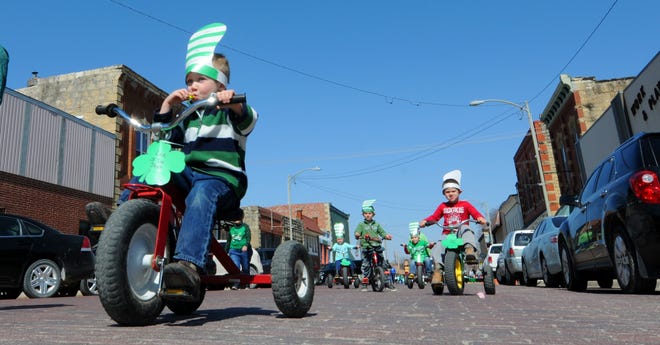 Children from the Munchkin Manor preschool and child care ride Wednesday morning down Marshall Street during the annual Chapman St. Patrick's Day Parade. [TOM DORSEY / SALINA JOURNAL]