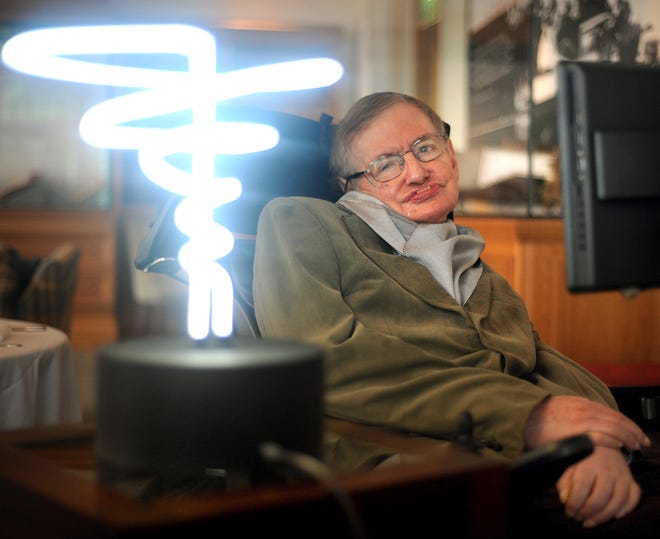 Professor Stephen Hawking poses Feb. 25, 2012, beside a lamp titled 'black hole light' by inventor Mark Champkins, presented to him during his visit to the Science Museum in London. (Anthony Devlin/PA via AP)