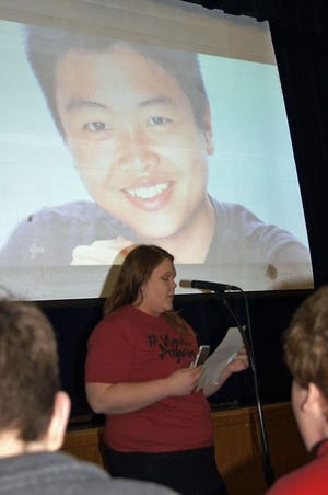 Mercer County High School junior Lauren Morby reads the biography of Peter Wang, 15, who was shot Feb. 14 in Parkland, Fla., as he held a door open to let others get to safety. Morby spoke at an assembly March 14, one month after the Florida school shooting.