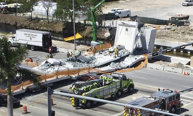 Emergency personnel respond to a collapsed pedestrian bridge at Florida International University on Thursday in the Miami area. The brand-new pedestrian bridge collapsed onto a highway crushing several vehicles. [The Associated Press]