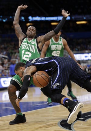 Orlando's D.J. Augustin falls after he was fouled while trying to get past Terry Rozier (12) during the first half of 93-82 Celtics victory over the Magic on Friday night in Orlando, Fla. [AP Photo/John Raoux]