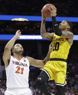 UMBC's Jairus Lyles (10) shoots over Virginia's Isaiah Wilkins (21) during the second half of a first-round NCAA Tournament game in Charlotte, N.C. UMBC shocked the Cavaliers, the first time a No. 16-seed team has defeated a No. 1 seed in tournament history. [The Associated Press]