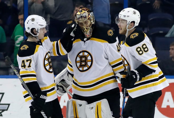 Bruins defenseman Torey Krug (47) and right wing David Pastrnak celebrate with goaltender Tuukka Rask after the Bruins defeated the Tampa Bay Lightning Saturday night.