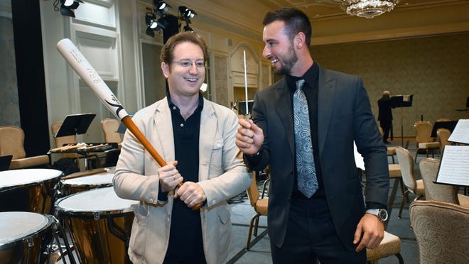 Symphony conductor Ramon Tebar trades his baton for a bat with St. Louis Cardinals shortstop Paul DeJong during the Palm Beach Symphony’s annual gala at The Breakers. (Melanie Bell / Daily News)