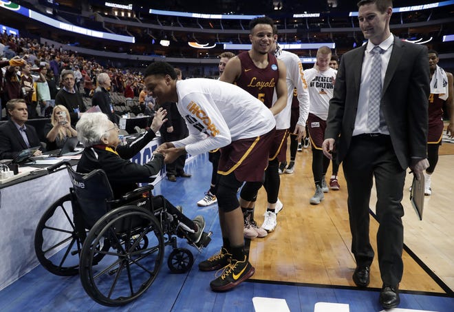 Sister Jean Dolores Schmidt, left, greets the Loyola-Chicago basketball team as they walk off the court after their win over Miami in a first-round game at the NCAA college basketball tournament in Dallas, Thursday, March 15, 2018. (AP Photo/Tony Gutierrez)