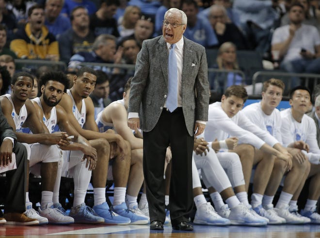 Aaron Rohlman, second from right, looks on as North Carolina head coach Roy Williams reacts to a play during the second half of UNC's game against Texas A&M on Sunday. [AP Photo/Bob Leverone]
