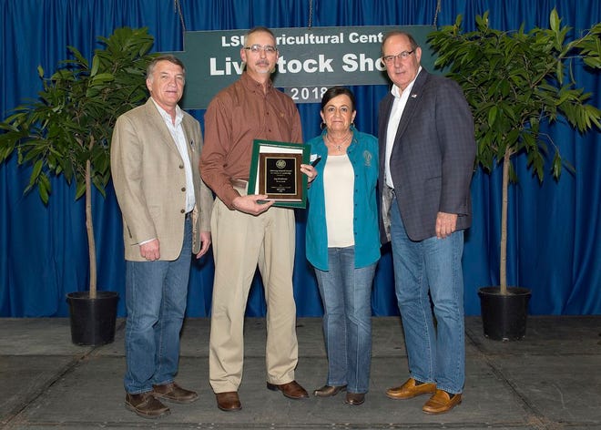 Iberia Parish 4-H volunteer leader Jay Boudreaux, second from left, receives the Attorney General's Award during a ceremony held at the conclusion of the 83rd annual LSU AgCenter Livestock Show on Feb. 17, 2018. From left, AgCenter associate vice president Mark Tassin; Boudreaux; Dianne Cashio, a representative of Louisiana Attorney General Jeff Landry; and LSU Vice President for Agriculture Bill Richardson.