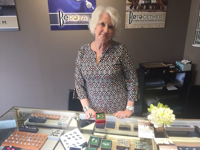 PHIL LUCIANO/JOURNAL STAR Ronda Daily stands next to a cufflinks display case at her Bremer Jewelry, 4707 N. University St. In a burglary last week, taken was $200 in charitable donations, plus three pairs of cufflinks.
