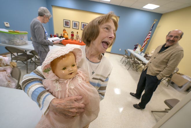 Harriet Brinker, organizer of Saturday's Unique Doll and Craft Show, shows one her favorite dolls as she and others prepare for the event. Proceeds will benefit two area veterans groups. [Alan Youngblood/Staff photographer]