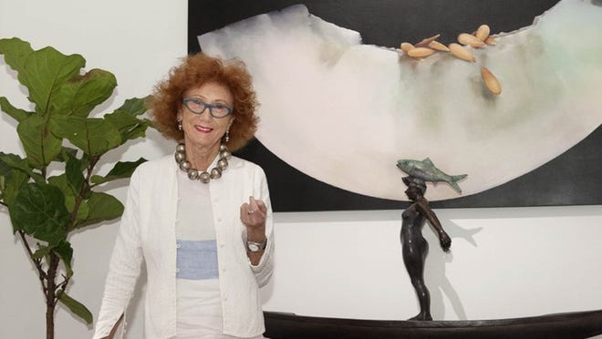 Palm Beach interior designer Jennifer Garrigues chose a minimalist decor to complement Luis Montoya’s and Leslie Oritz’s organic art, which includes the large painting and the sculpture behind her. (Meghan McCarthy / Daily News)