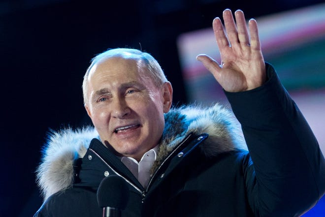 Russian President Vladimir Putin waves after speaking to supporters during a rally near the Kremlin in Moscow, Sunday, March 18, 2018. Vladimir Putin headed to an overwhelming win in Russia's presidential election Sunday, adding six years in the Kremlin for the man who has led the world's largest country for all of the 21st century.