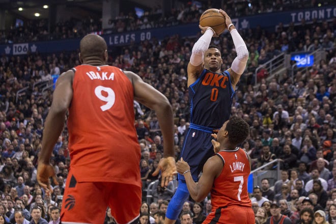 Oklahoma City Thunder's Russell Westbrook, center, shoots over Toronto Raptors Kyle Lowry, right, as Raptors' Serge Ibaka looks on during second half action in Toronto on Sunday. [Chris Young/The Canadian Press via AP]