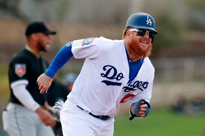 FILE - In this Friday, Feb. 23, 2018, file photo, Los Angeles Dodgers' Justin Turner runs to third from second after a throwing error by Chicago White Sox second baseman Yoan Moncada during the third inning of a baseball spring exhibition game, in Glendale, Ariz. Turner has a broken left wrist after being hit by a pitch during a spring training game, Monday, March 19, 2018. (AP Photo/Carlos Osorio, File)