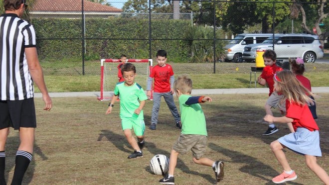 Green Team winners Frank Coniglio passes the ball to teammate Brody Lefo in Rosarian’s kindergarten competition of soccer refereed by parent volunteer Nick Coniglio. Courtesy of Rosarian Academy