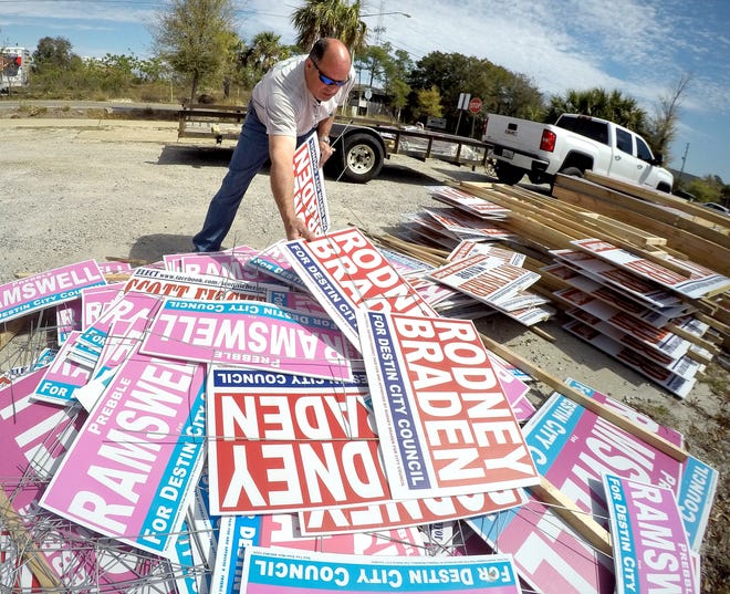 Destin Councilman Rodney Braden collects his campaign signs from a lot in Destin. Braden said he will be saving the signs for possible future campaigns. A city ordinance gives candidates 21 days after election day to remove their signs, but candidates traditionally have collected their signs far more quickly. [NICK TOMECEK/DAILY NEWS]