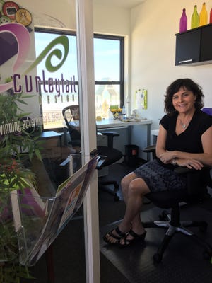 Kim Fitzgerald, owner of Curley Tail Design, in the office space she shares with Marketing 2 Go in Flagler Beach. Fitgerald's firm is celebrating its 20th anniversary this year. [News-Tribune/Aaron London]
