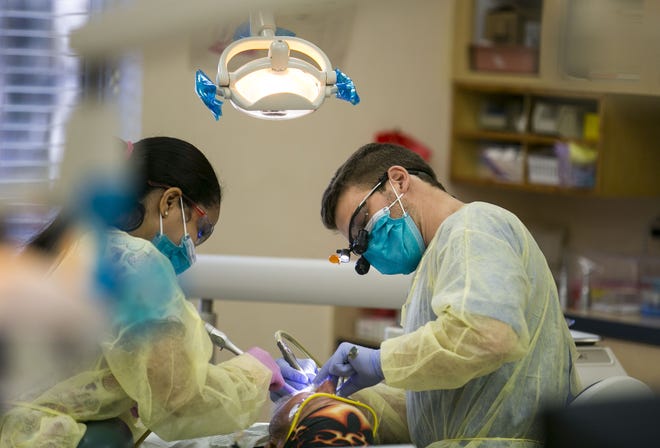 Certified dental assistant Briana Alva, left, and University of Florida dental student Kyle Houston cleans a patient's teeth at the ACORN Clinic in Brooker. The clinic received $750,000 in funding from the Florida Legislature in the 2018-19 state budget. [Alan Youngblood/Special to the Guardian]