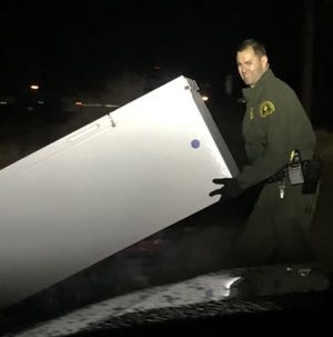 Deputy Montes with the San Bernardino County Sheriff's Victor Valley Station returns a refrigerator recovered from a reported residential burglary Tuesday evening. [Photo courtesy of the San Bernardino County Sheriff's Department]