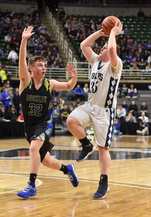 Colt senior Nolan Sullivan attempts a shot over Buckley's Tyler Francisco during the MHSAA Class D state semifinals at the Breslin Center on the campus of Michigan State University. [TODD LANCASTER PHOTO]