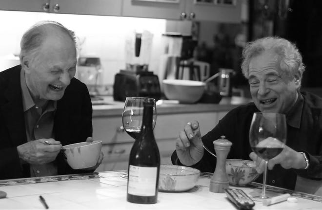 Itzhak Perlman and actor Alan Alda share a laugh at dinner in the documentary "Itzhak." [Greenwich Entertainment]