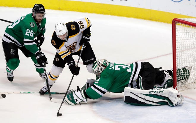 Boston's David Pastrnak, center, goes around Dallas goalie Kari Lehtonen and scores the game-winning goal with 12 seconds remaining in Friday's game.