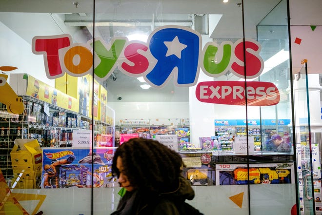 A pedestrian passes in front of a Toys R US store in New York on March 15, 2018. [Bloomberg photo by Christopher Lee]