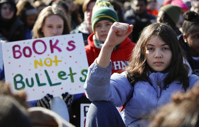 Students sit in front of the White House in Washington during an organized rally on March 14. [AP FILE]