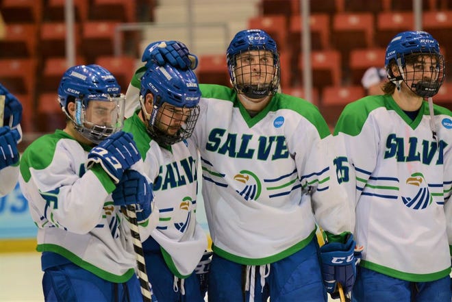 Colin Clapton rests his golve on the helmet of Jack Billings while Salve Regina players watch the St. Norbert Green Knights receive their awards following Saturday's NCAA Division III men's ice hockey championship game at the Olympic Center in Lake Placid, N.Y.
