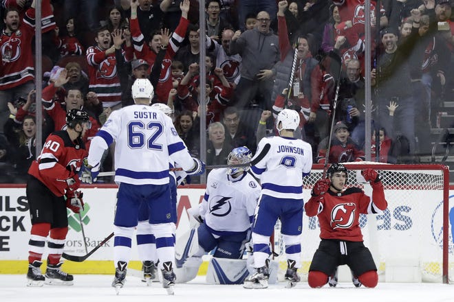 New Jersey Devils' Nico Hischier, right, celebrates his first-period goal against the Tampa Bay Lightning on Saturday night at the Prudential Center in Newark, N.J. [The Associated Press]