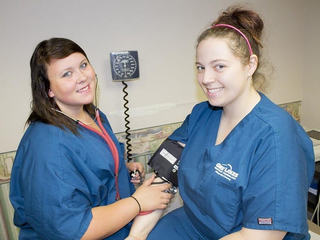 Great Lakes Institute of Technology medical assistant students Chelsea Loney and Ashley Bierbach work on practical skills. [CONTRIBUTED PHOTO]