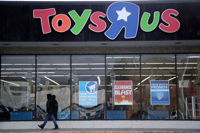 FILE- This Jan. 24, 2018, file photo shows a person walking near the entrance to a Toys R Us store, in Wayne, N.J. Toys R Us is opening its doors with a going-out-of-business sale, offering clearance discounts at all 735 stores, including Babies R Us. The company did not say Friday, March 23, how big the discounts will be or when it expects stores to shut down. (AP Photo/Julio Cortez, File)