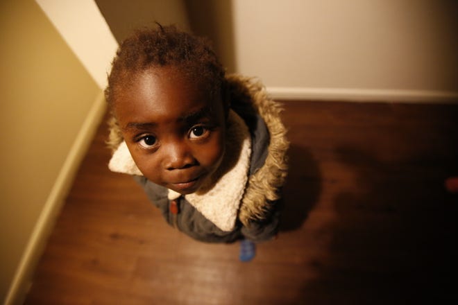 Moza Ausa, a 4-year-old refugee from the war-torn Democratic Republic of Congo, stands in the family's new apartment in Columbus, Ohio, during the early morning hours of Thursday, Feb. 22, 2018. The family, including six children, had just flown to Columbus from Africa. The DRC is not included in the Trump administration's travel ban. (AP Photo/Martha Irvine)
