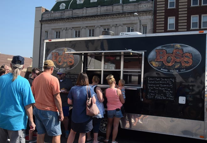 Customers wait for their food at the Boss Food Truck on a Saturday afternoon during the first Food Truck and Art Festival in Galesburg last fall. [BILL NICE/The Register-Mail]