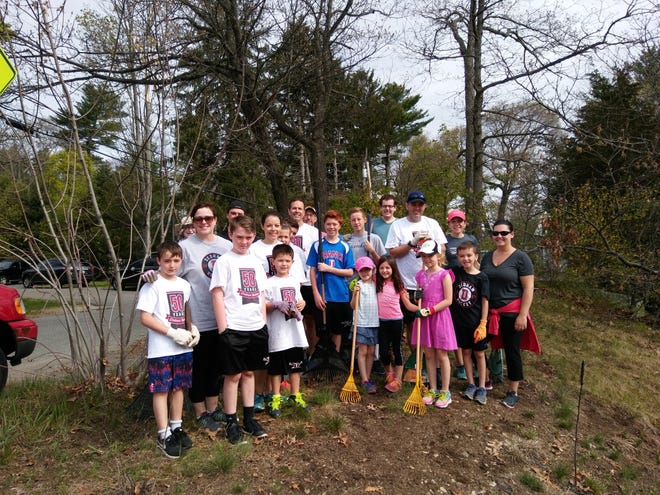 Members of Dedham Youth Hockey, their families and other community members came out in 2017 for Townwide Clean Up day to work on the new Sponsor-A-Spot at Washington and Highlands streets. [Courtesy Photo]